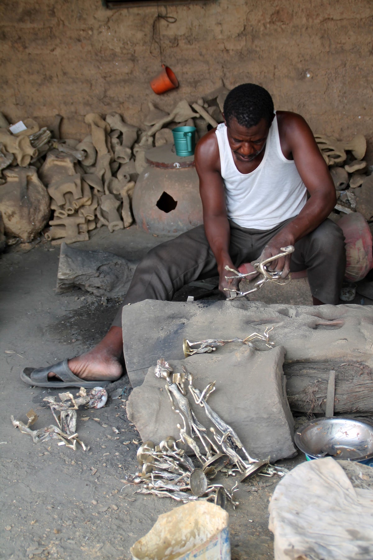 A clay mould broken by hand to free the bronze