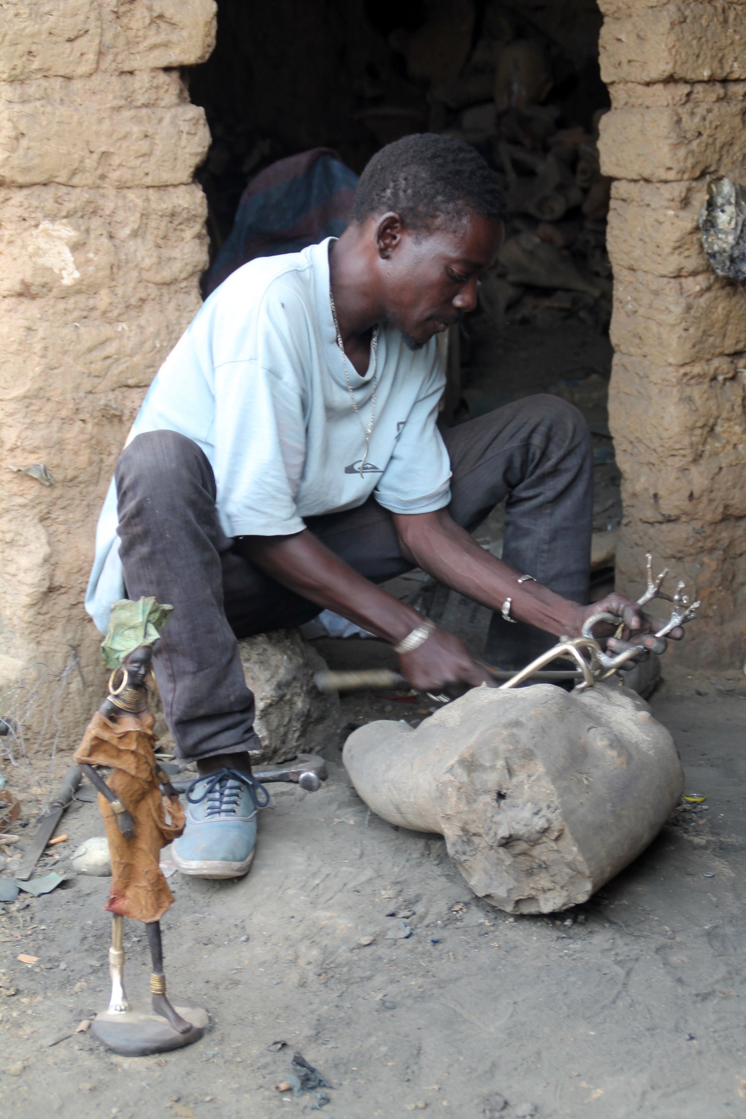 African artisan hand-finishing a bronze statue in Burkina Faso